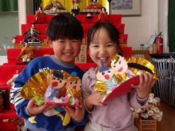 年少児がお雛様と写真を撮る様子