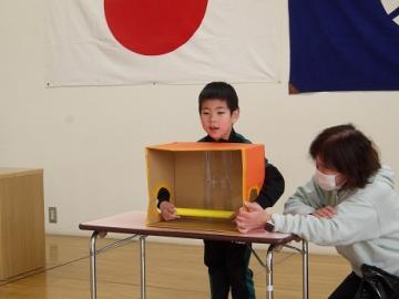 幼児が箱に手を入れて何が入っているか当てるゲームをしている様子