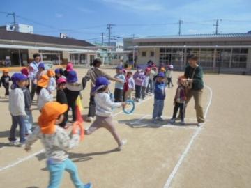 園庭で、みんなでリレーをしている園児たちの様子