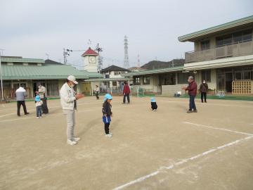 園庭で、老人クラブのみなさんと竹とんぼで遊んでいる園児たちの様子