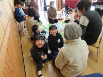 遊戯室で、老人クラブのみなさんとお手玉で遊んでいる園児たちの様子