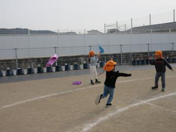 園庭で、凧揚げで遊んでいる4歳児たちの様子