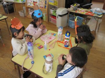 室内で、恵方巻を食べている園児たちの様子