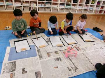 3歳児が室内で書初めをしている様子