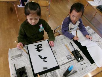 5歳児が室内で書初めをしている様子