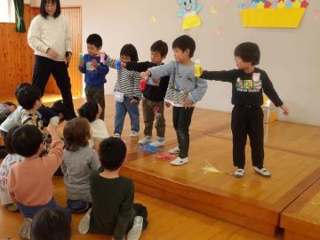 遊戯室のステージ上に立っている子供たちが、手に持った水の色が変わる手品をしている