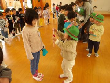 5歳児に手作りのメダルをプレゼントする3歳児