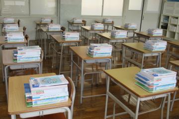 7年生の教室で、各机に新しい教科書が置かれている様子