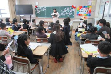 教室で担任の先生が1年生と保護者の方に説明をしている様子