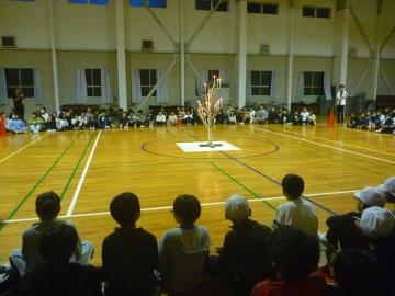 体育館でキャンドルサービスを行っている児童の様子