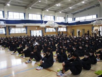 体育館で座り、話を聞く生徒たちの様子