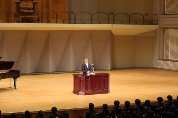 パルナソスホールの壇上での学校長講話の様子