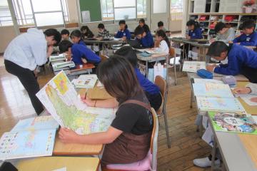 4年生が地図帳などの資料を使って調べ学習をしている様子