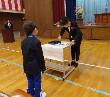 入学式で、新入生のために色紙を書く校長