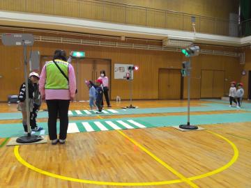 1年生が、交通安全協会の方に信号機がある横断歩道の渡り方を聞いている。