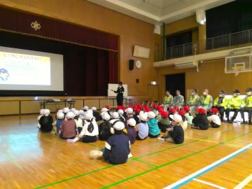 1年生が、警察の方に交通安全についての話を聞きながらスライドを見ている。