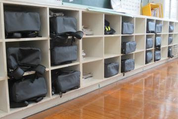 教室の後ろの棚に整理されたカバンの写真
