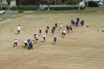 6年生が運動場で体育の授業に取り組んでいる様子