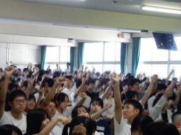 講演会を聴いて手を挙げる生徒のようす