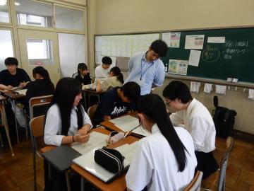 教室内で、ワークシートに取り組む生徒たちを指導する教員の様子