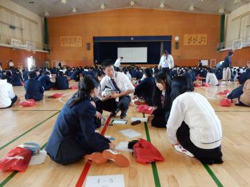 課題に取り組む生徒と声をかける職員のようす1