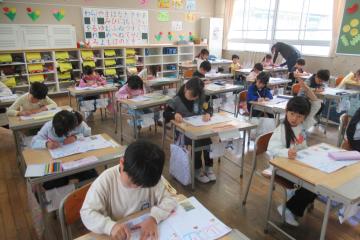 教室内で1年生がひらがなを書いて字を学習している様子