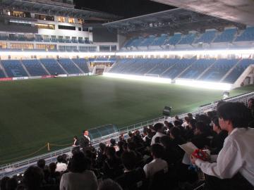 スタジアムの観客席に座る生徒たちの様子