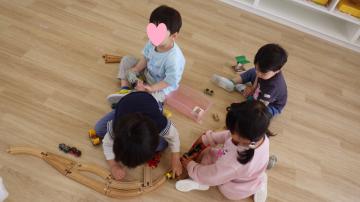 3歳児が保育室で汽車積木をして遊んでいる様子