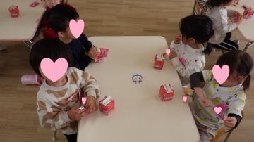 保育室でおやつを食べる3歳児