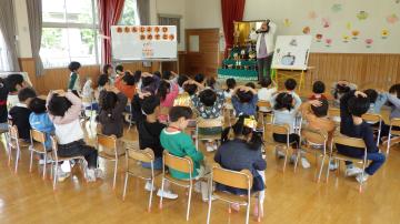誕生会で、みんなでお楽しみのパネルシアターを見ている様子
