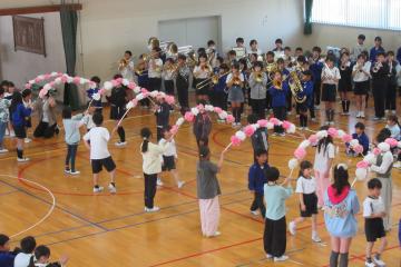 1年生が花のアーチを通り体育館に入場している様子