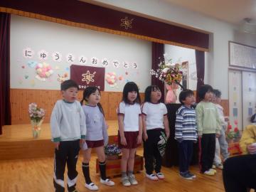 舞台下で並んで、新入園児に向けてメッセージを伝えている子供たち