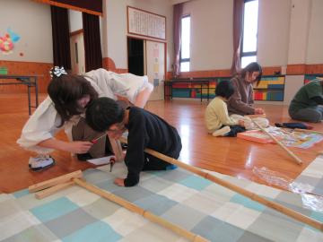 竹馬の足場の板をネジでとめる親子