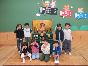 五月人形の前でクラス全員で写真を撮っている様子