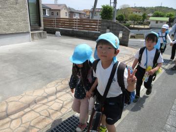 友達と手をつないで公園まで一緒に歩いている様子