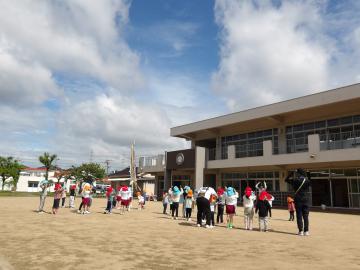 園庭で異年齢ペアでダンスをしている園児たちの様子