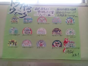 緑の背景に手作り風の丸いイラストが列状に並び見出しと小さな文字が上部に書かれ右下に赤い人物イラストがある掲示板の写真