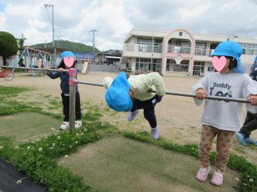 園庭で鉄棒をしている園児たちの様子