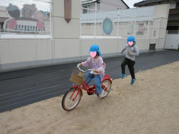 園庭で自転車に乗っている園児の様子