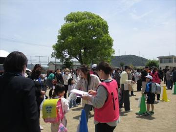 担任の先生が引き渡しカードを確認しながら保護者の方に児童を引き渡しています