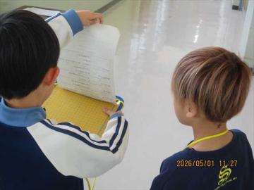 2年生が教室の前で教室の名前やどんなことをする教室かを丁寧に説明しています。