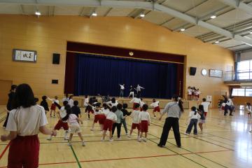 体育館で全校ダンスの練習をしている写真