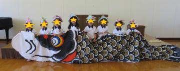 大きなこいのぼりと一緒に記念撮影する子ども達