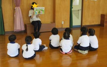 こどもの日の由来についての紙芝居を見る子ども達
