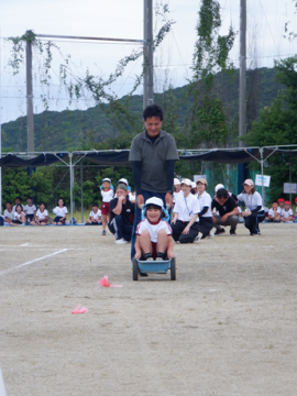 校庭で園児たちが親子競技に参加しているところ