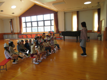 こどもの日のつどいで、遊戯室で話を聞いているところ
