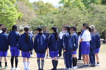 生徒が公園で輪を作って並んでいます。