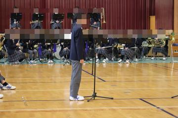 体育館で生徒会長が新入生に挨拶をしています。