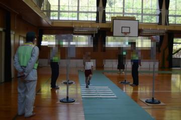 体育館に設置された模擬信号機を見て交差点を渡る練習をする児童たちの様子