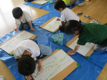 幼児がエンドウマメやスナップエンドウの絵をかいている
